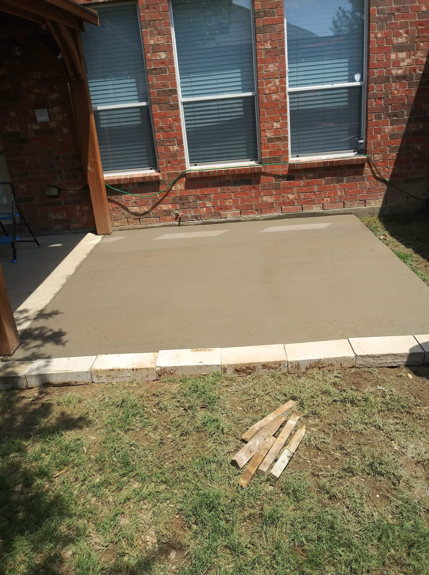 Small concrete patio edged with light masonry blocks